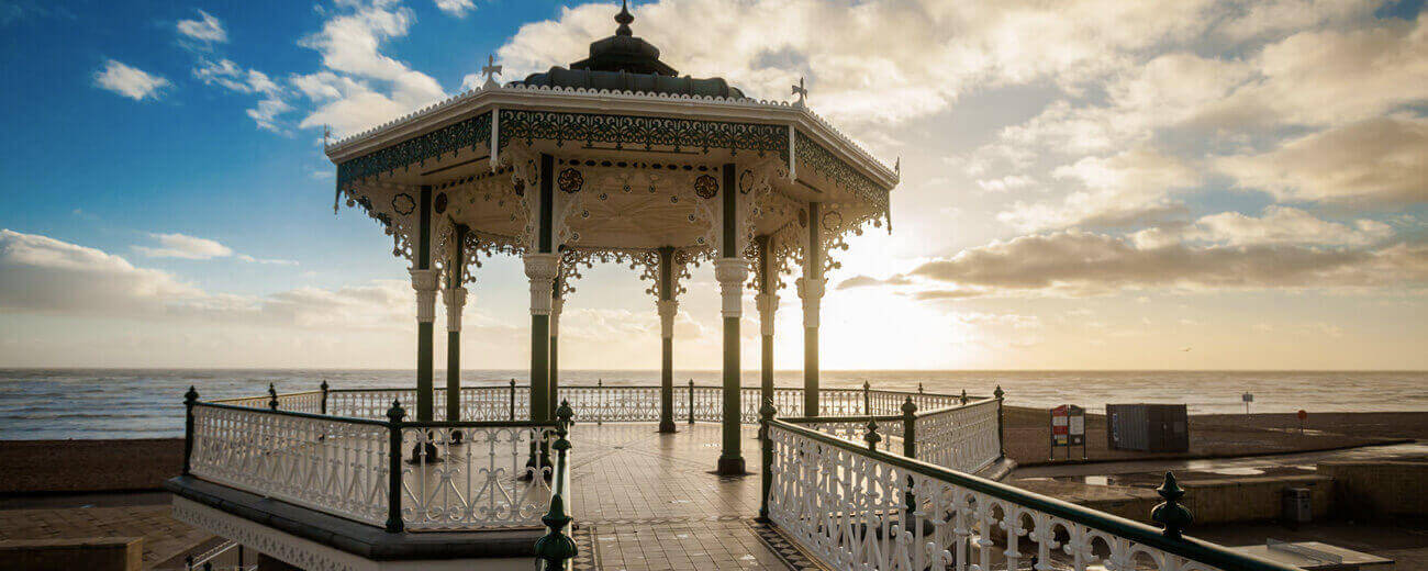 Victorian bandstand on the Brighton Promenade, Great Britain.  Sunset and sea in the distance.