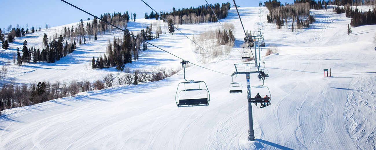Snow covered terrain, with ski lift transporting people up the mountain hills, Aspen, Colorado.